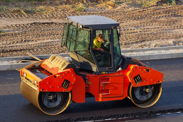 industrial landscape with rollers that rolls a new asphalt on the road. Repair work, complicated transport movement