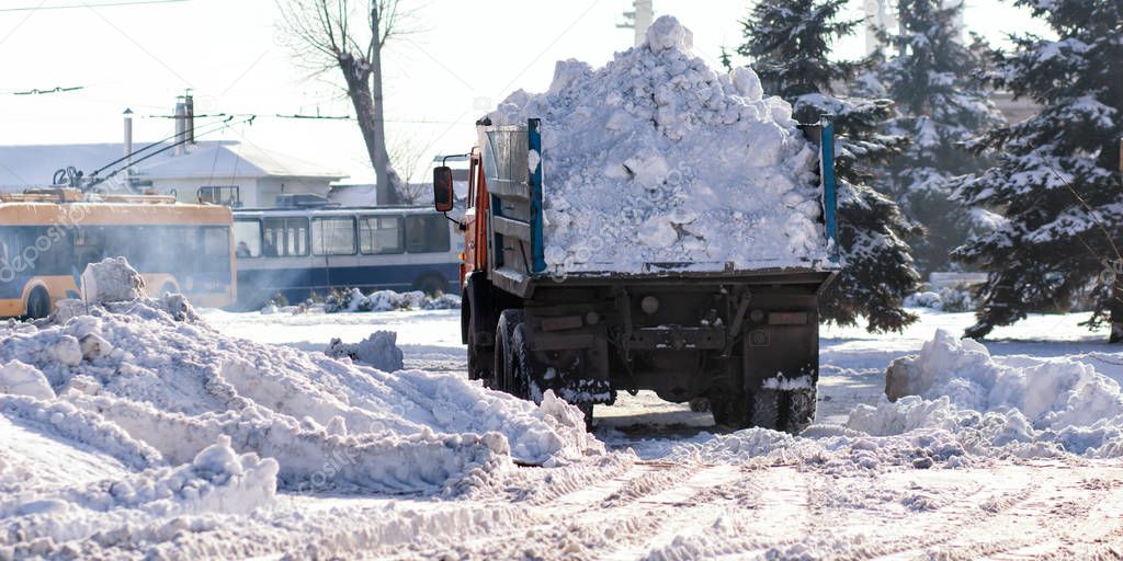 Snow-removal machine cleans the street of snow.