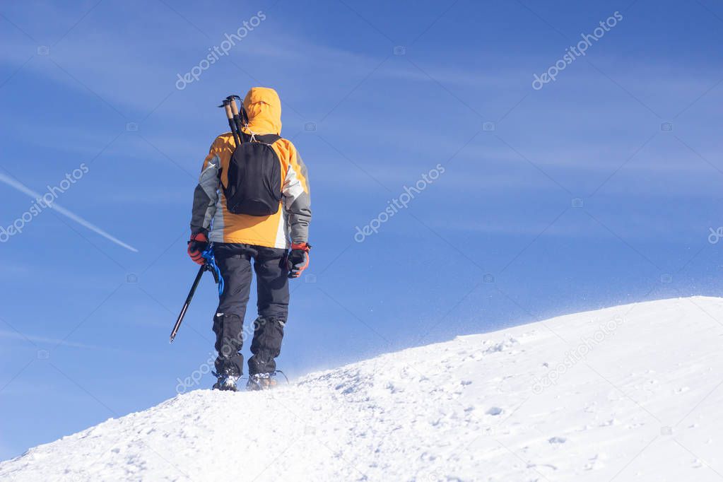 Tied climbers climbing mountain with snow field tied with a rope with ice axes and helmets.