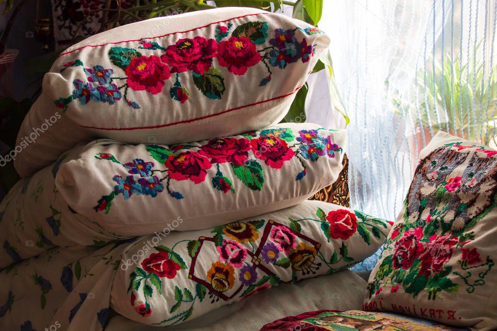 An ancient iron bed with embroidered cushions.Old Iron Bed with pillows.Embroidered pillows on an old bed. Ukrain traditional