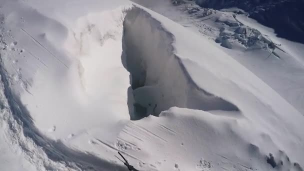 Діра на вершині гірського снігу — стокове відео