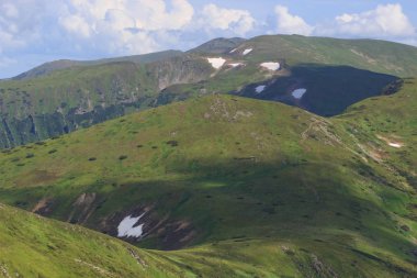 Güzel yeşil dağlar tepeler ve bulutlu mavi gökyüzü.