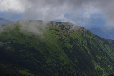 Güzel yeşil dağlar tepeler ve bulutlu mavi gökyüzü