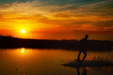 Wakeboarder günbatımı üzerinde hileler yapmak.