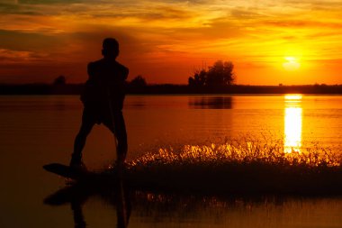 Wakeboarder günbatımı üzerinde hileler yapmak.
