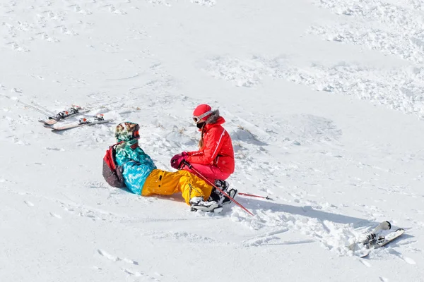 Lovers skiers in funny hats in mountains.