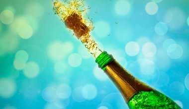 Bir şişe champange açılıyor. Mavi bir arka plan üzerinde izole