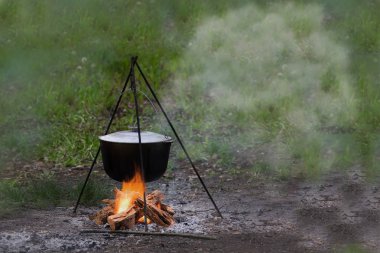 Açık ülke yan yemekler ile kazan metal kap su ısıtıcısı doğa Kampı'nda yemek kamp ateşi ile camp yakınındaki ortasında açık pişirme için ateş geleneksel çanak