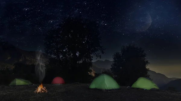 Night bivouac in Mountains, milion star hotel under night sky, red illuminated tent on pass in Alps