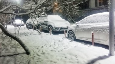 Arabalar gece karla kaplı.