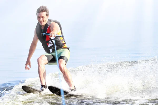 closeup man riding water skis on lake in summer. Water active sport. Space for text