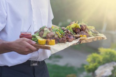 Garson, ızgara et ve sebze sunan,