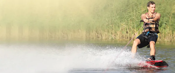 Wakeboarder si allena nel lago nella giornata di sole. Spazio per il testo. Vista panoramica — Foto Stock