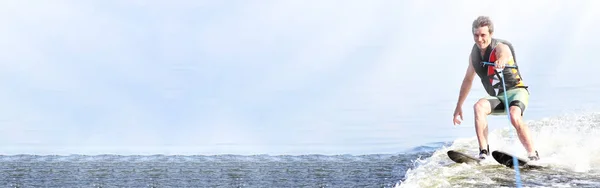 closeup man riding water skis on lake in summer at sunny day. Water active sport. Space for text. Panoramic view