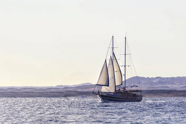 Παλιό αρχαίο πλοίο σε ειρηνικό ωκεανό το ηλιοβασίλεμα. Ήρεμη αντανάκλαση των κυμάτων, ήλιος. Αντιγραφή χώρου — Φωτογραφία Αρχείου