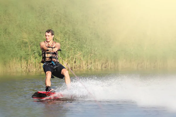 Trenes wakeboarder en el lago en el día soleado. Espacio para texto — Foto de Stock