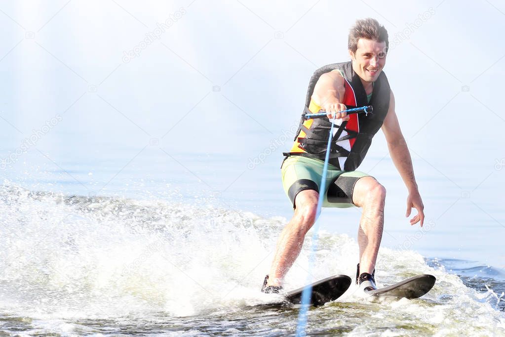closeup man riding water skis on lake in summer at sunny day. Water active sport. Space for text