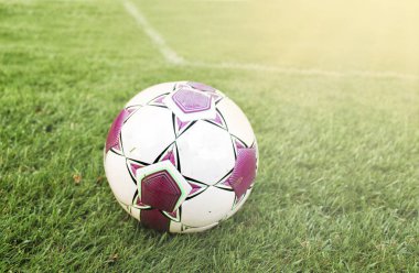 Güneşli bir günde yeşil çimüzerinde futbol topu
