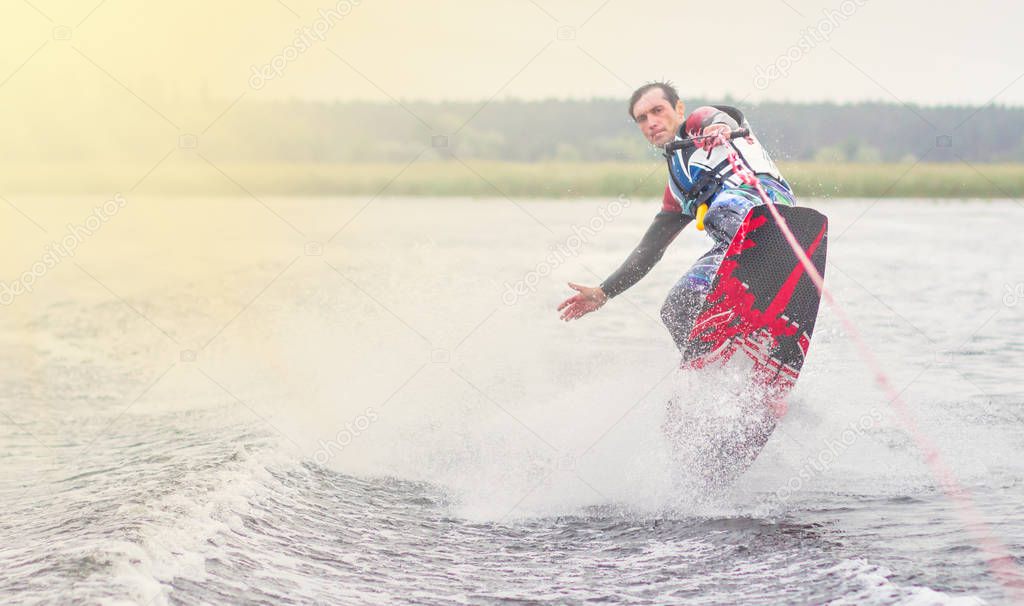 wakeboarder trains in the lake at sunny day. Space for text