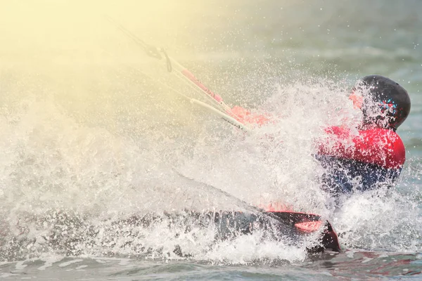 Kitesurfen. De jonge man vliegt op de zee Golf op het bord op zonnige dag — Stockfoto