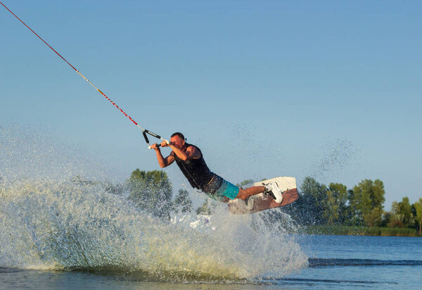 Cherkassy, Ukraine - July 19, 2019: Wakeboarder showing of tricks and skills at wakeboarding event in Cherkassy