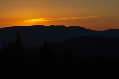 Dağ, vadi ve lagün manzaralı sonbahar manzarası. Tepenin yamaçları kızıl arktous ile kaplıdır. Dağların üzerinde güneş ışınları ile Inanılmaz gün batımı.