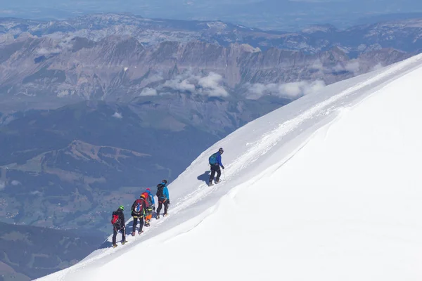 Mont Blanc, Frankrijk - 10 augustus 2018: klimmers met grote rugzakken klim de Mont Blanc naar het base camp Tete Rouse — Stockfoto