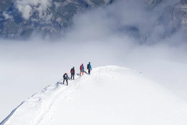 Mont Blanc, Frankrijk - 10 augustus 2018: klimmers met grote rugzakken klim de Mont Blanc naar het base camp Tete Rouse — Stockfoto