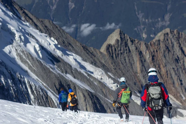 Mont Blanc, Frankrijk - 10 augustus 2018: klimmers met grote rugzakken klim de Mont Blanc naar het base camp Tete Rouse — Stockfoto