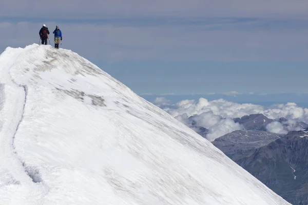 Mont Blanc, Francja - 10 sierpień 2018: wspinaczy z dużymi plecakami wspiąć się na szczyt Mont Blanc podstawowy obozu Tete Rouse — Zdjęcie stockowe