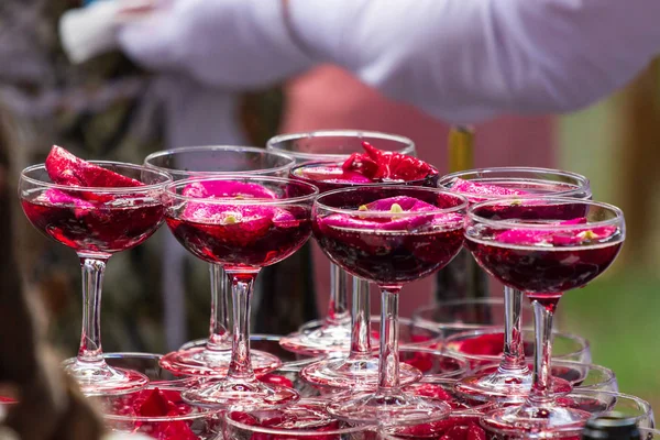 Une pyramide de verres à champagne avec des pétales de rose — Photo