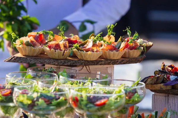 Beautifully decorated catering banquet table with different food snacks and appetizers with sandwich, caviar, fresh fruits on corporate christmas birthday party event or wedding celebration — Stock Photo, Image