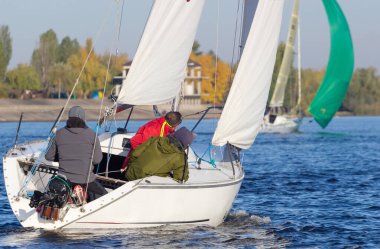 Nehirde yelkenli teknede insanlar