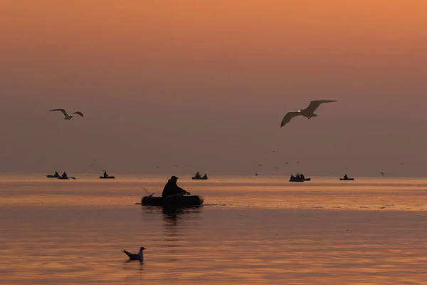 Рыбалка кружится на закате. Силуэт рыбака — стоковое фото