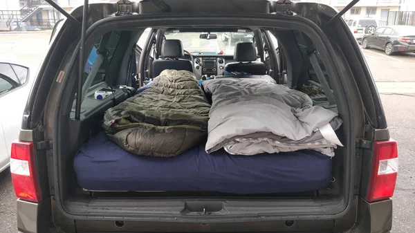 Büyük bir cipin arkasında tam boy yataklı 2 uyku tulumu. Kamp için hazır.