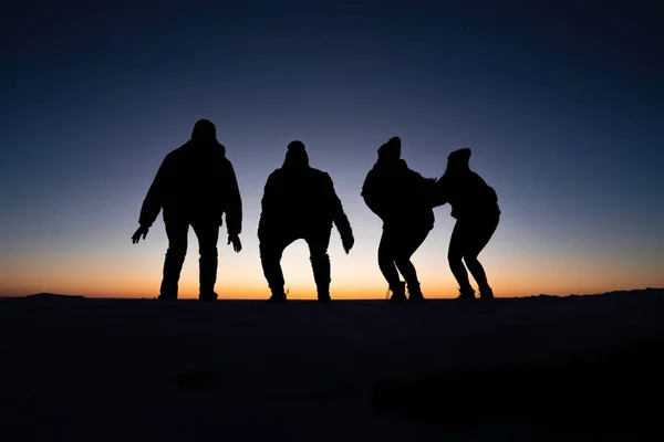 Colorado 'daki Masa Tepesi Dağı' nın tepesinde güneşin doğuşunda zıplayan 4 gencin silueti.