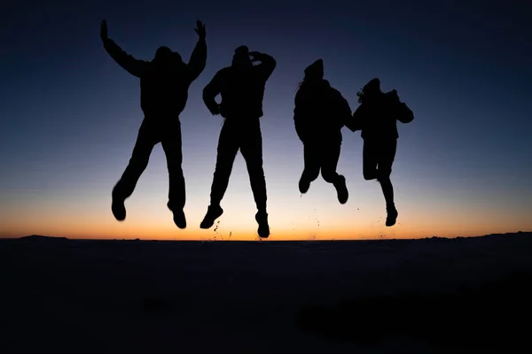 Colorado 'daki Masa Tepesi Dağı' nın tepesinde güneşin doğuşunda zıplayan 4 gencin silueti.
