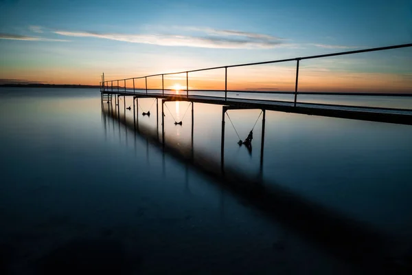 Sakin okyanusta sığ bir iskelede güzel bir gün doğumu.