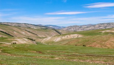 Yuvarlanan Moğol yeşil tepeleri ve dağları, mavi bulutlu gökyüzü