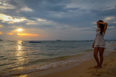 Gün batımında Ba Keo sahilinde yürüyen Asyalı bir kadın, Phu Quoc, Vietnam