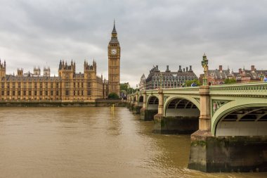 Londra 'da bulutlu bir günde Westminster Köprüsü ve Thames Nehri' nin yanında Big Ben.