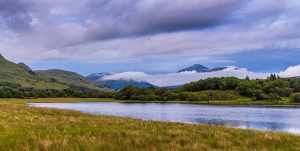 Argyll, İskoçya 'da bir yaz gecesinde alacakaranlıkta Loch Dewe' un üzerine alçak bulutlar ve sis çöktü.