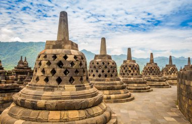 Borobudur Budist tapınağının tepesindeki çan gibi görünen Stupalar, arka planda bir volkan, Yogyakarta, Endonezya
