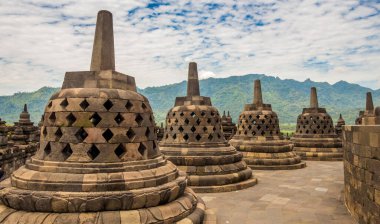 Borobudur Budist tapınağının tepesindeki çan gibi görünen Stupalar, arka planda bir volkan, Yogyakarta, Endonezya