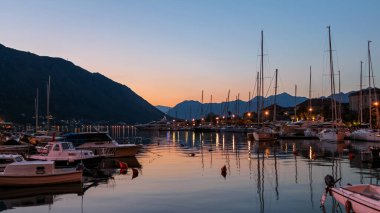 Karadağ 'ın UNESCO Dünya Mirasları Bölgesi olan Eski Kotor Kasabası' nın limanına yansıyan günbatımı