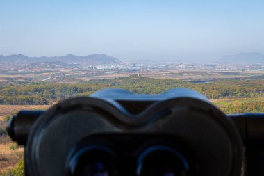 A view into North Korea across the DMZ from South Korea, from behind binoculars at the Dorsa Observatory in Paju clipart