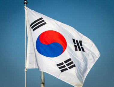 Güney Kore bayrağı rüzgarda savruluyor Arındırılmış Bölgede, açık mavi gökyüzü