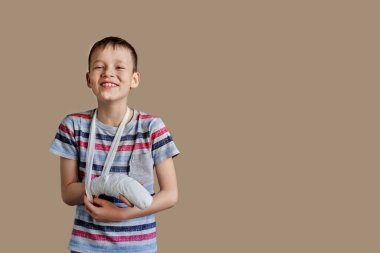 a child in a striped t-shirt with a bandage wrapped around his arm. Arm injury clipart