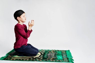 Müslüman bir çocuk Ramazan tatilinde dua eder.