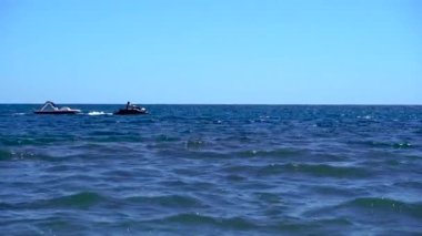 Bir jet ski sırayla denize katamaran taşır.